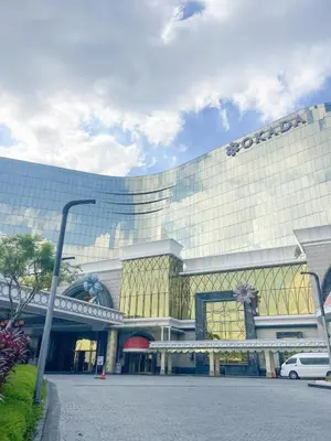 a large building with a car parked in front of it at Cozy 3BR in Manila Bay near Okada II 12pax in Manila
