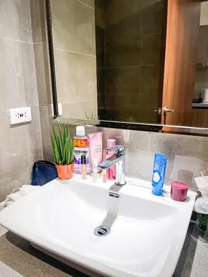 a bathroom sink with cosmetics and a mirror at Lovely Penthouse near Airport, City of Dreams 8pax in Manila