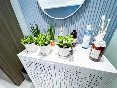 a table with three potted plants and a mirror at Lovely Penthouse near Airport, City of Dreams 8pax in Manila