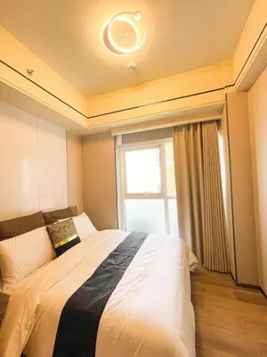 a bedroom with a large bed with a window at Luxurious 2BR with Manila Bay Sunset II 6pax in Manila