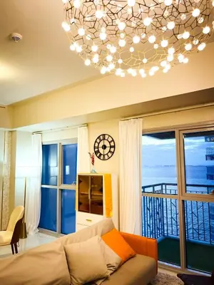 a living room with a couch and a chandelier at Lovely & Modern 1BR in Manila across Okada in Manila