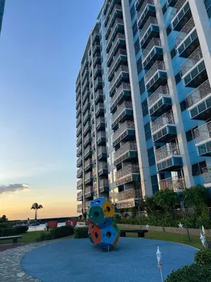 a large apartment building with a sculpture in front of it at Lovely & Modern 1BR in Manila across Okada in Manila