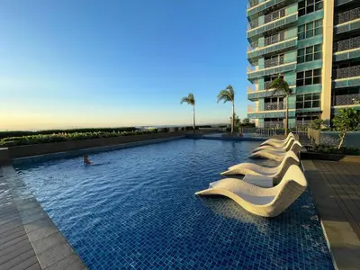 a large swimming pool with a person in a surfboard at Luxury 2BR beside Okada Manila in Manila
