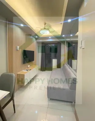 a room with a bed and a desk and a television at Serene Suite at Shore 3 in Manila