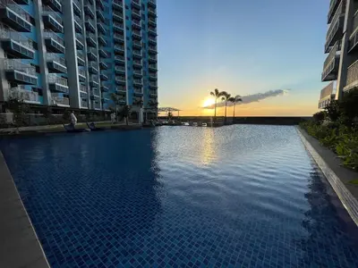 a large swimming pool with a sunset in the background at Modern 2BR beside Okada Manila with Sunset View in Manila
