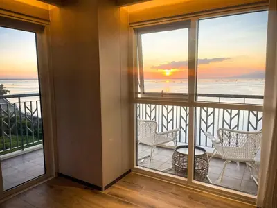 a room with a balcony with a view of the ocean at Modern 2BR beside Okada Manila with Sunset View in Manila