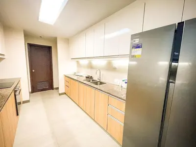 a kitchen with a stainless steel refrigerator and wooden cabinets at Modern 2BR beside Okada Manila with Sunset View in Manila