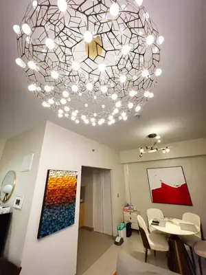 a living room with a large chandelier at Luxurious 1BR in Bayshore w Sunset View near Okada in Manila