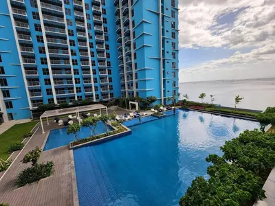 an overhead view of a swimming pool in front of buildings at Luxurious 1BR in Bayshore w Sunset View near Okada in Manila