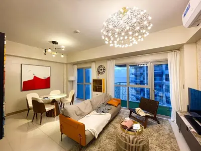 a living room with a couch and a table at Luxurious 1BR in Bayshore w Sunset View near Okada in Manila