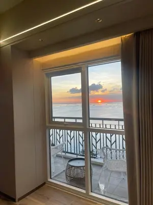 a room with a balcony with a view of the ocean at Luxurious 3BR in Manila Bay across Okada II 12pax in Manila