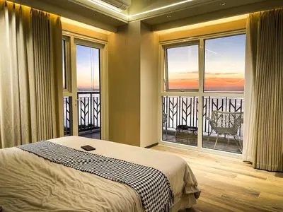 a bedroom with a bed and a large window at Luxurious 3BR in Manila Bay across Okada II 12pax in Manila