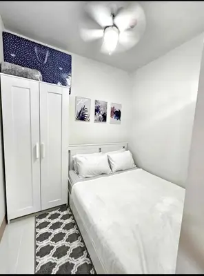 a bedroom with a bed and a ceiling fan at New Crib at Shore 3 in Manila