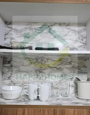 a counter with cups and glasses on a shelf at New Crib at Shore 3 in Manila