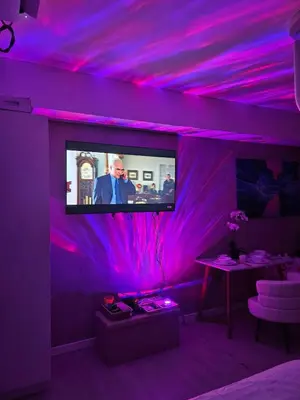 a room with a purple ceiling with a tv on it at One Bedroom at Azure Urban Near Airport in Manila