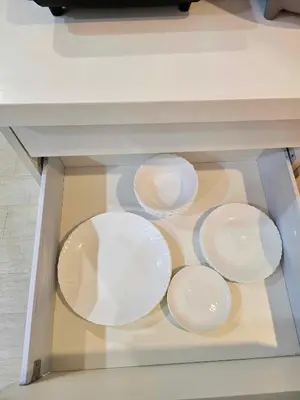 a glass table with white plates on it at One Bedroom at Azure Urban Near Airport in Manila