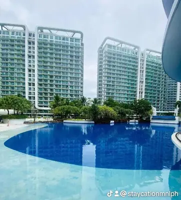 a large swimming pool in front of two large buildings at One Bedroom at Azure Urban Near Airport in Manila