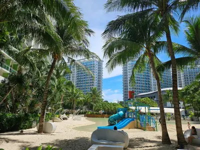 a playground with palm trees and a slide at One Bedroom at Azure Urban Near Airport in Manila