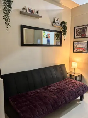 a black couch in a room with a mirror at Sea Residences by Sonny in Manila