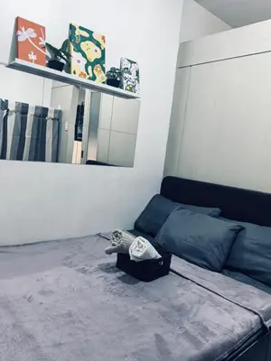 a bedroom with a bed and a mirror at Sea Residences by Sonny in Manila