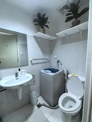 a bathroom with a toilet and a sink at Sea Residences by Sonny in Manila