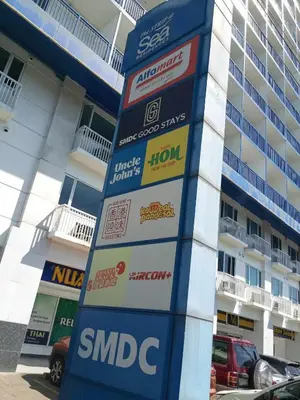 a gas station sign in front of a building at Sea Residences by Sonny in Manila