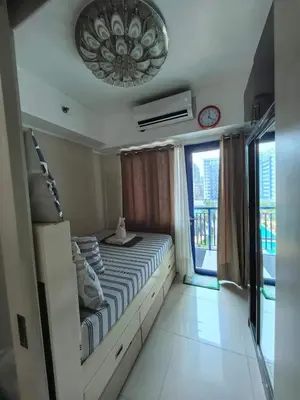 a bedroom with a bed and a clock on the ceiling at Athalia's Pad at Sea Residences in Manila