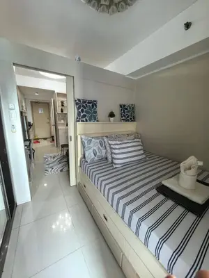 a bedroom with a large bed with striped sheets at Athalia's Pad at Sea Residences in Manila
