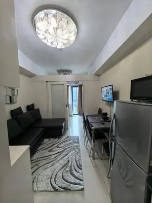 a living room with a couch and a table at Athalia's Pad at Sea Residences in Manila