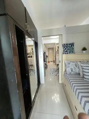 a small bedroom with a bed and a mirror at Athalia's Pad at Sea Residences in Manila