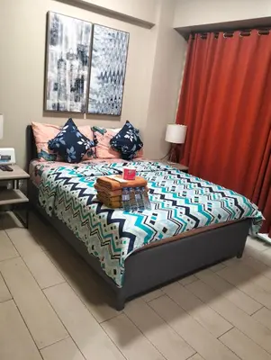 a bedroom with a bed and a red curtain at Two Palm Tree Villas by Nadz6 in Manila