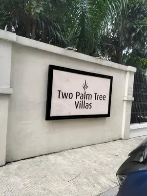 a sign for two palm tree villas on a wall at Two Palm Tree Villas by Nadz6 in Manila