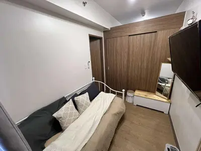 a room with a couch in the corner of a room at Owls Nest Staycation in Manila
