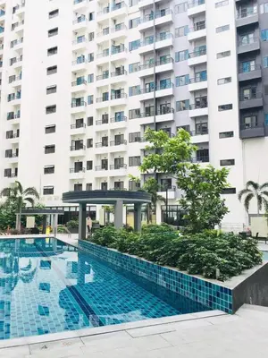 a swimming pool in front of a large building at Owls Nest Staycation in Manila
