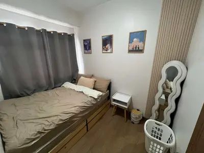 a small bedroom with a bed with a gray canopy at Owls Nest Staycation in Manila