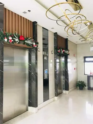 a row of elevators in a lobby with flowers at Owls Nest Staycation in Manila