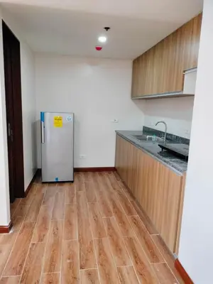 a kitchen with a refrigerator and a wooden floor at Manila Airport Accommodation at NAIA road in Manila