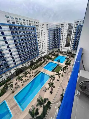 an aerial view of a hotel with two pools and palm trees at Gab's Crib - Staycation near Mall of Asia in Manila