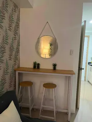 a table with two stools and a mirror on the wall at Gab's Crib - Staycation near Mall of Asia in Manila