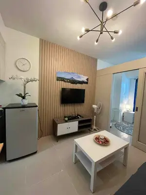 a living room with a tv and a white table at Gab's Crib - Staycation near Mall of Asia in Manila