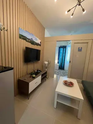 a living room with a table and a tv in it at Gab's Crib - Staycation near Mall of Asia in Manila