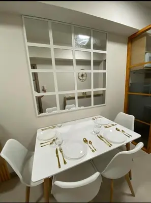 a white table with white chairs and a mirror at Happy Sunshine at S Residences in Manila