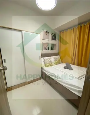 a small bedroom with a bed and a window at Happy Sunshine at S Residences in Manila