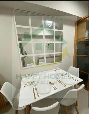 a white table with white chairs and a mirror at Happy Sunshine at S Residences in Manila