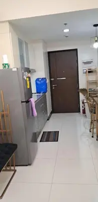 a kitchen with a refrigerator and a door in a room at 101 Newport Blvd Condotel, Manila -Hyuna Place, Across NAIA T3 in Manila
