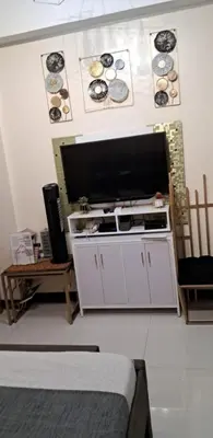 a living room with a television and a white cabinet at 101 Newport Blvd Condotel, Manila -Hyuna Place, Across NAIA T3 in Manila
