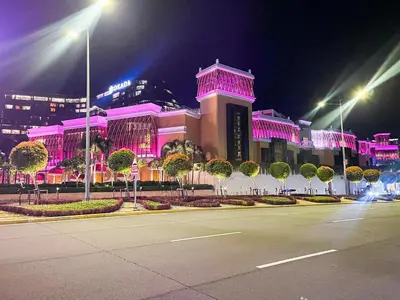 a large building with pink lights on it at night at Stunning 2BR across Okada Manila with Sunset View in Manila