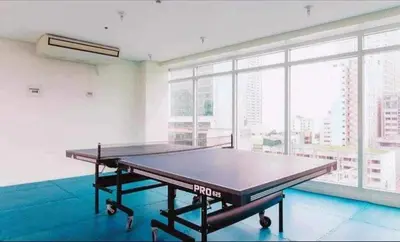 a ping pong table in a room with a large window at Birch Tower Condominium Malate Manila by T&T in Manila
