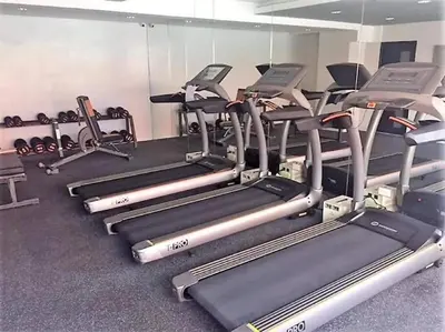 a gym with rows of treadmills and machines at Portovita North Tower 10A, 10C in Manila