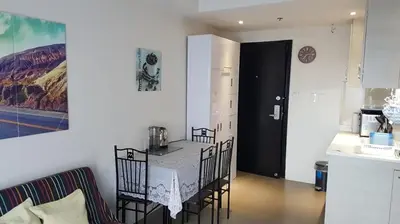 a kitchen with a table and chairs in a room at Portovita North Tower 10A, 10C in Manila
